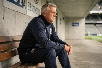 Eden Hazard en 2026 assis dans un tunnel de stade, portrait contemplatif d'un footballeur professionnel en reconversion ou retraite sportive