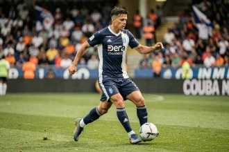 Footballeur argentin en action sur la pelouse d'un stade de Ligue 1 lors d'un match en 2026